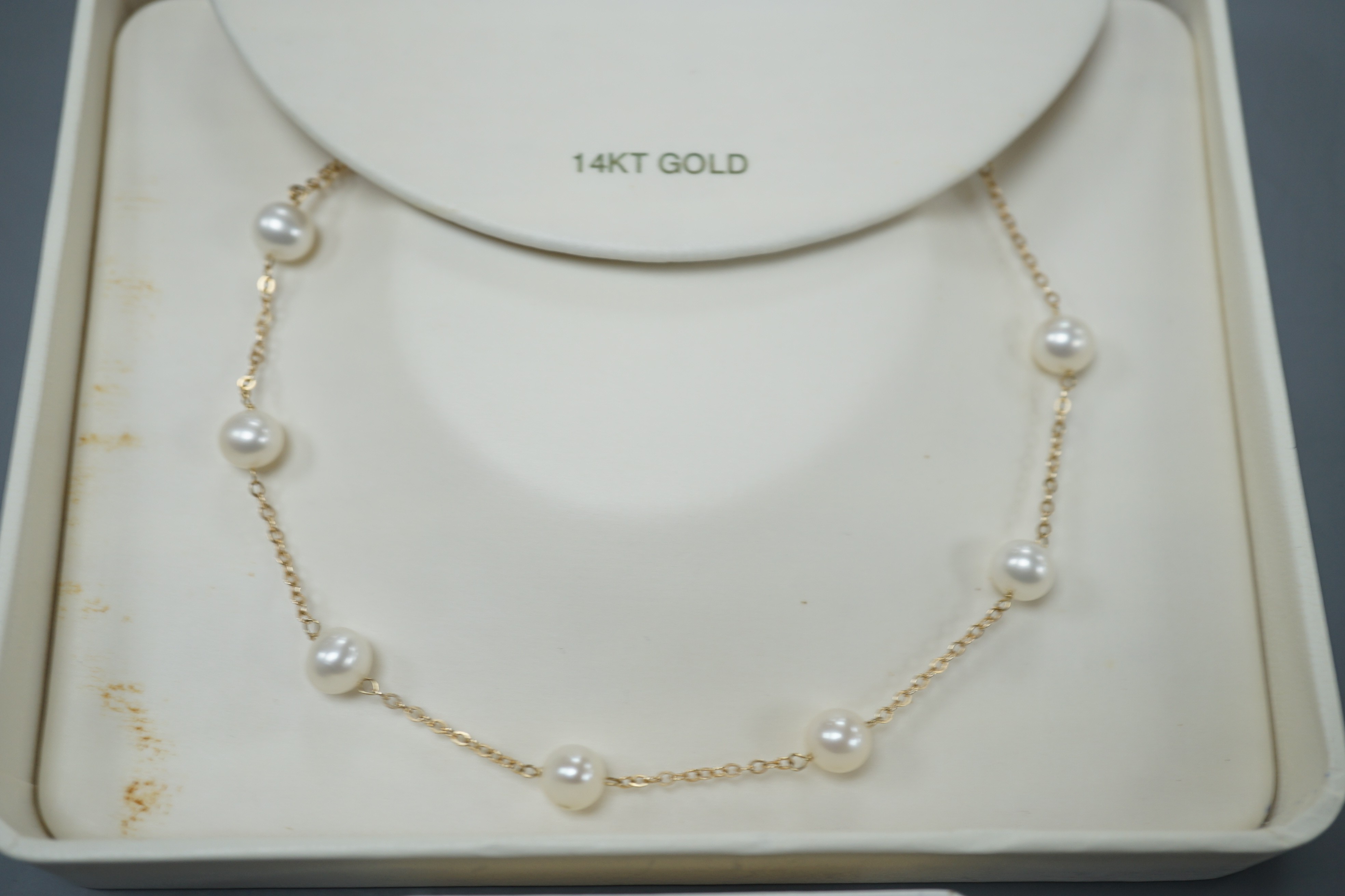 A boxed modern 14k and cultured pearl set necklace, 40cm and a pair of matching earrings.